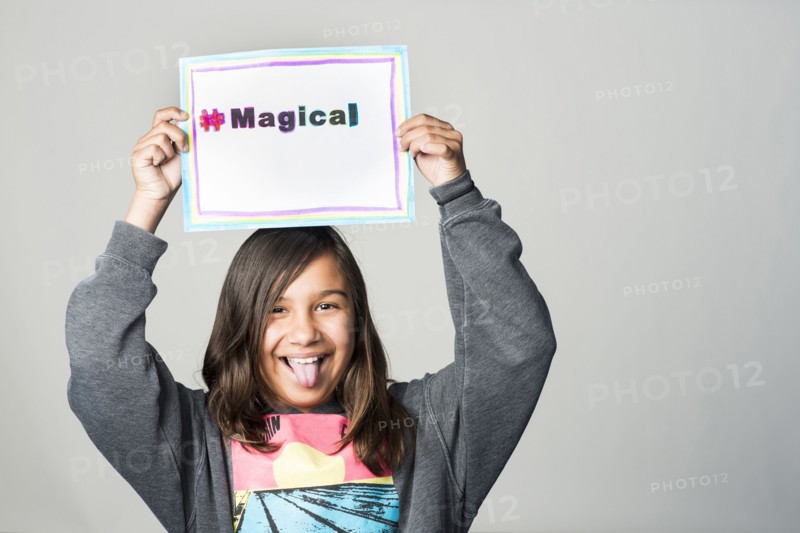 Hispanic girl holding magical sign above head