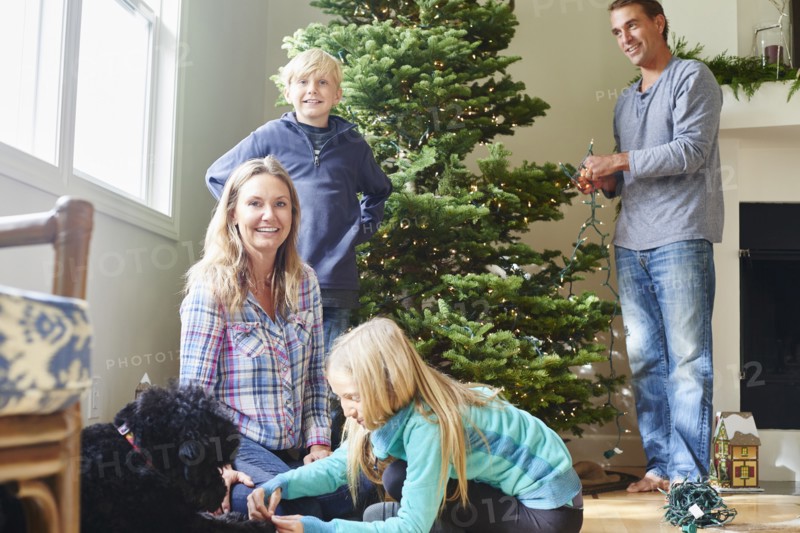 Caucasian family decorating Christmas tree