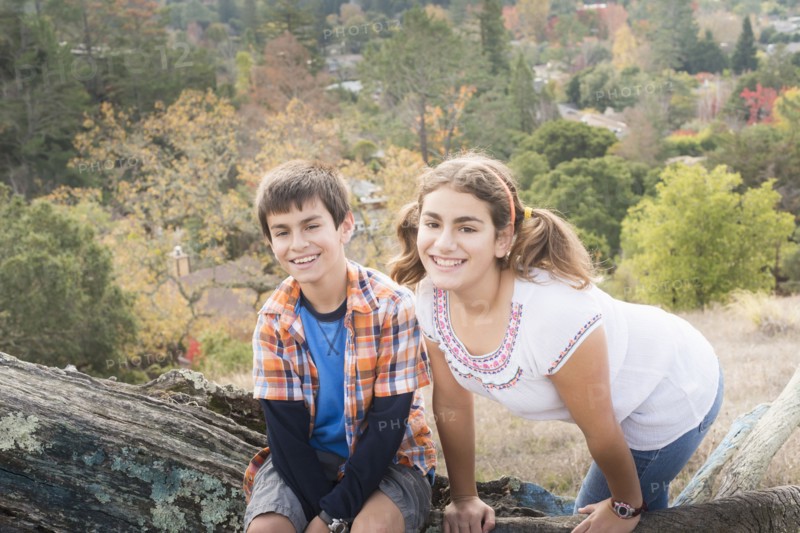 Mixed Race brother and sister posing on log