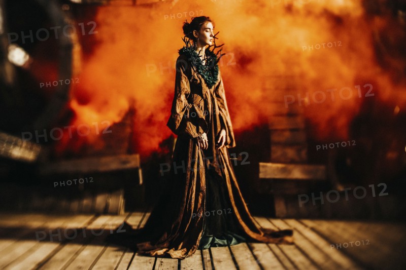 Caucasian woman wearing branch necklace and dress on stage