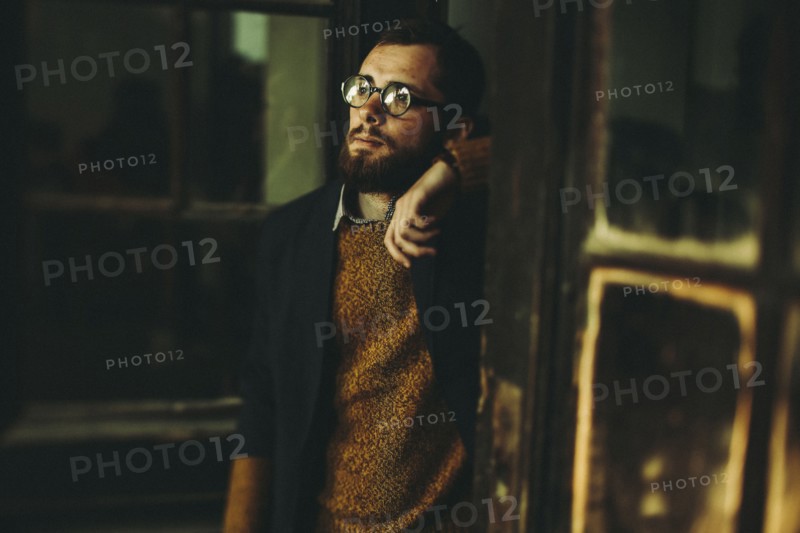 Caucasian an with beard leaning in doorway