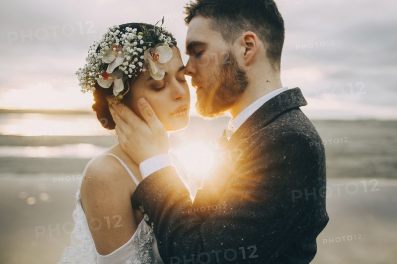 Caucasian bride and groom on sunny beach