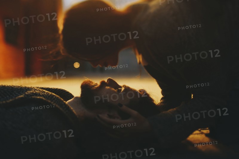 Caucasian woman caressing man laying on floor