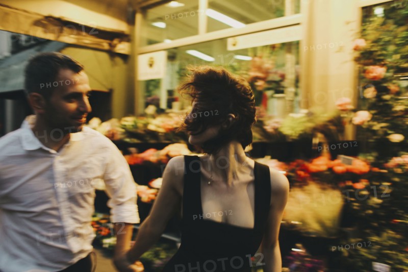 Caucasian couple rushing near florist