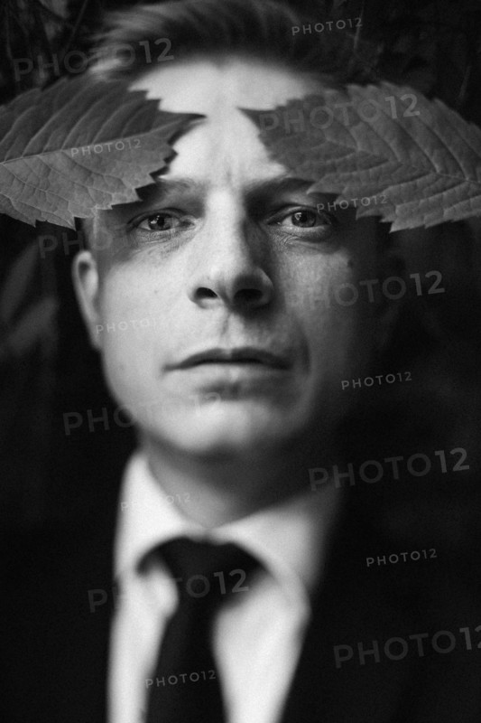 Caucasian businessman with leaves on forehead