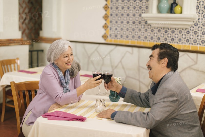 Older couple toasting with wine in restaurant