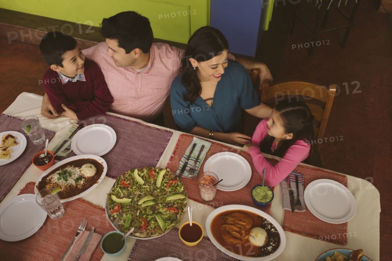 High angle view of Hispanic parents and children in restaurant