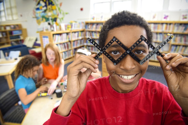 Boy playing with plastic blocks in library
