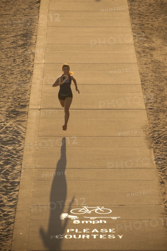 Mixed Race woman running on path near beach