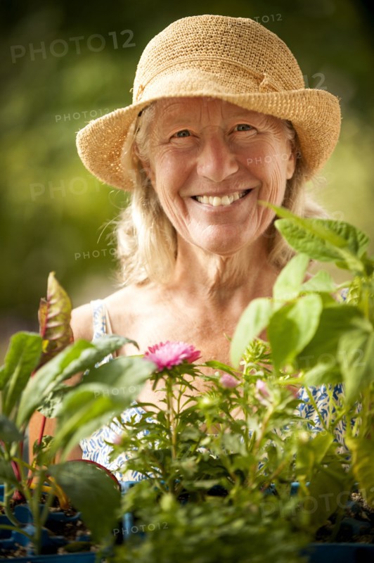 Portrait of smiling Caucasian woman holding tray of flowers