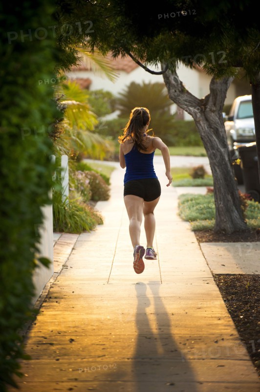 Mixed Race woman running on sidewalk