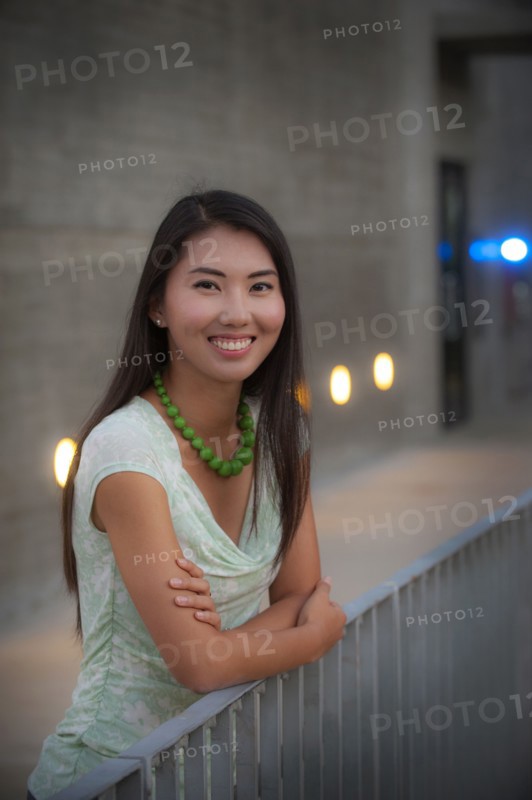 Portrait of smiling woman leaning on railing