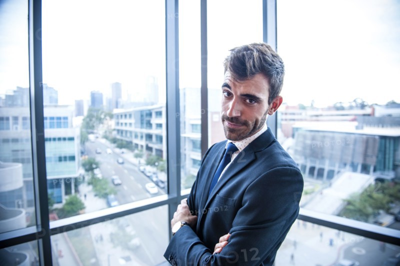 Portrait of serious Hispanic businessman posing near window