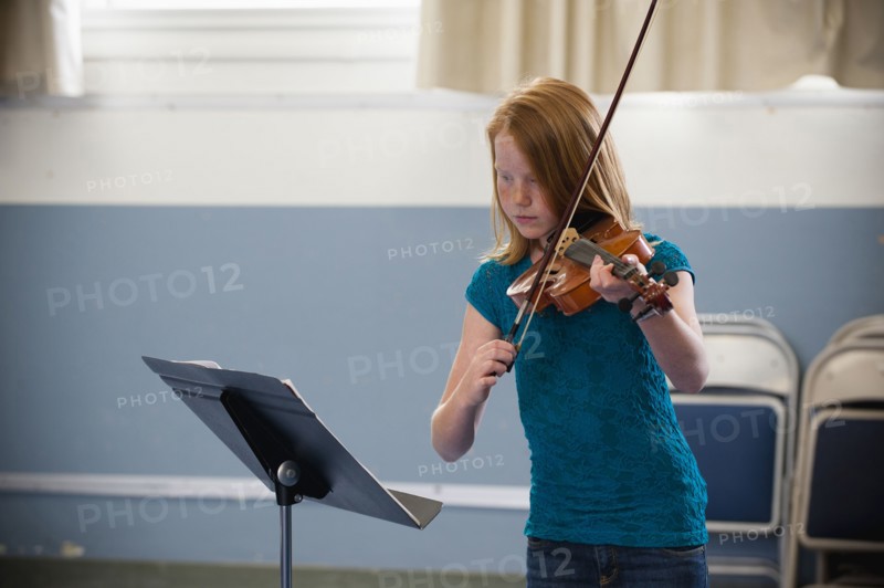 Caucasian girl practicing violin