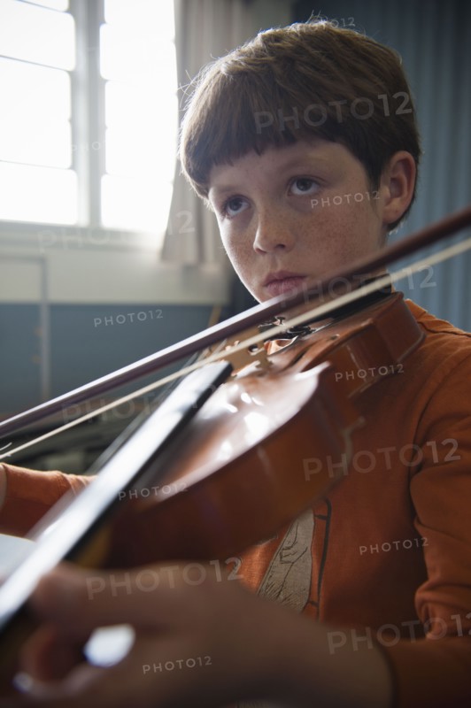 Close up of Caucasian boy practicing violin