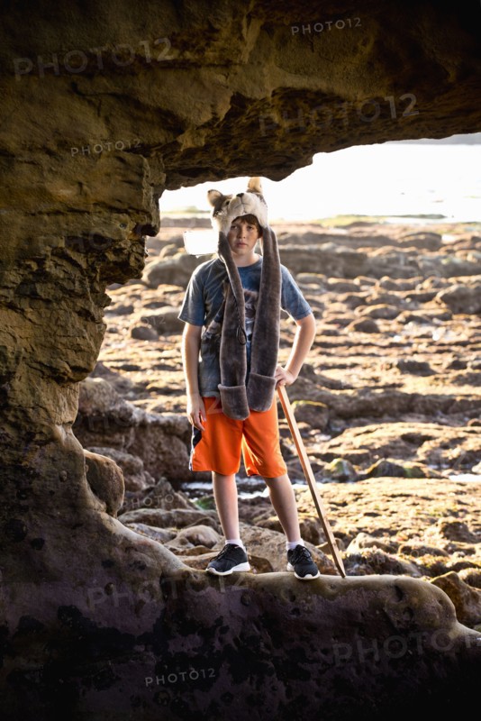 Portrait of Caucasian boy hiking on rocks at beach