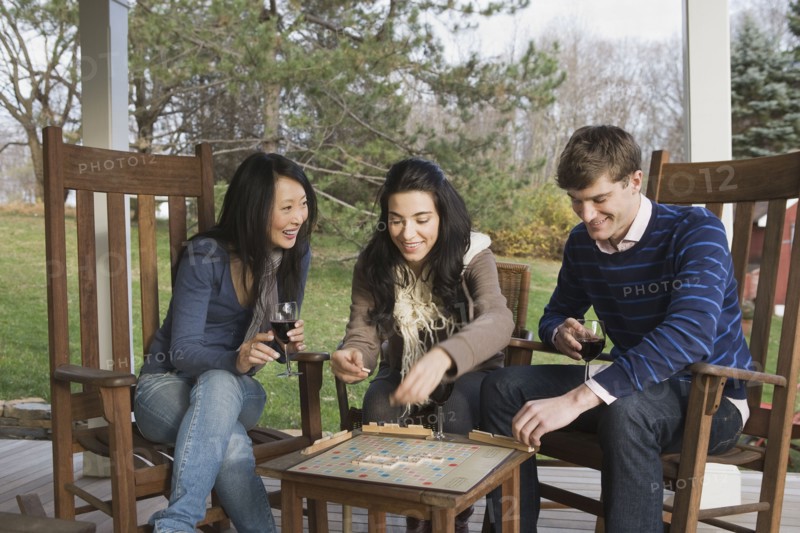 Friends playing scrabble on porch