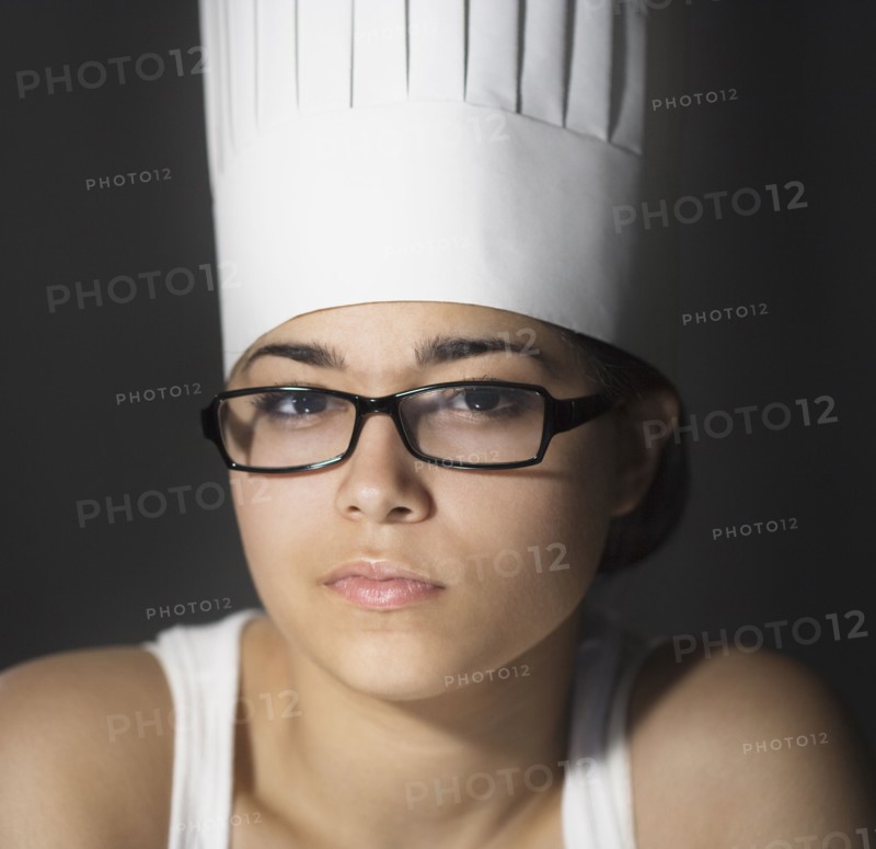 Hispanic woman in chef's hat and eyeglasses