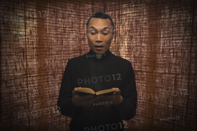 Pacific Islander priest reading bible