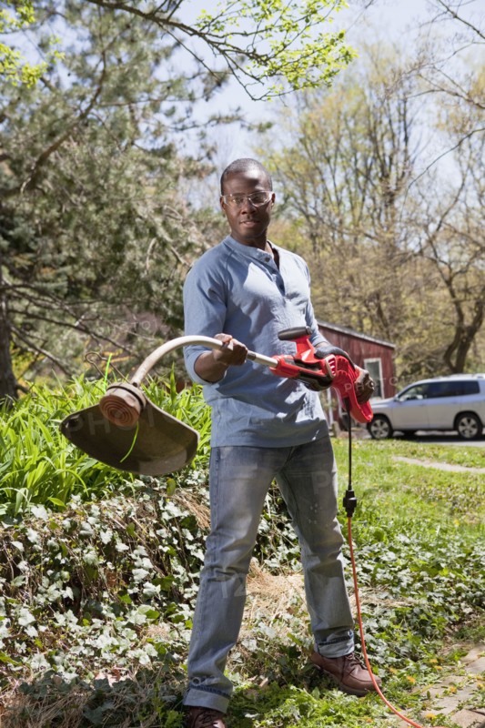 Black man holding weed trimmer