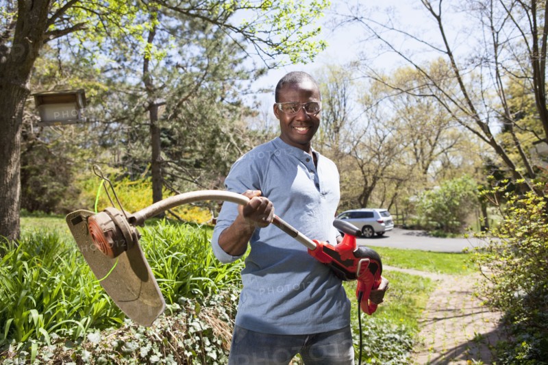 Black man holding weed trimmer