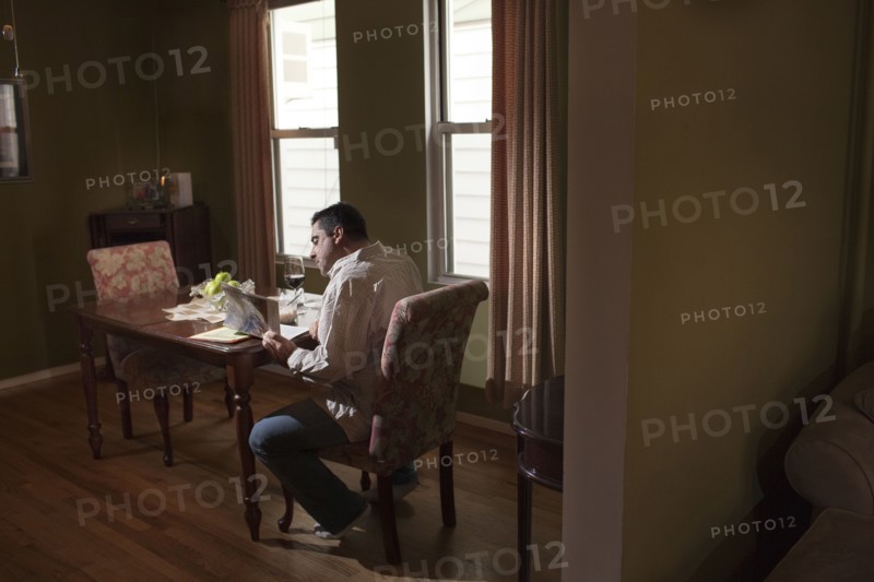 Caucasian man having dinner and reading