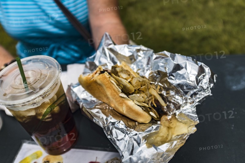 Woman holding hot dog and soda with ice
