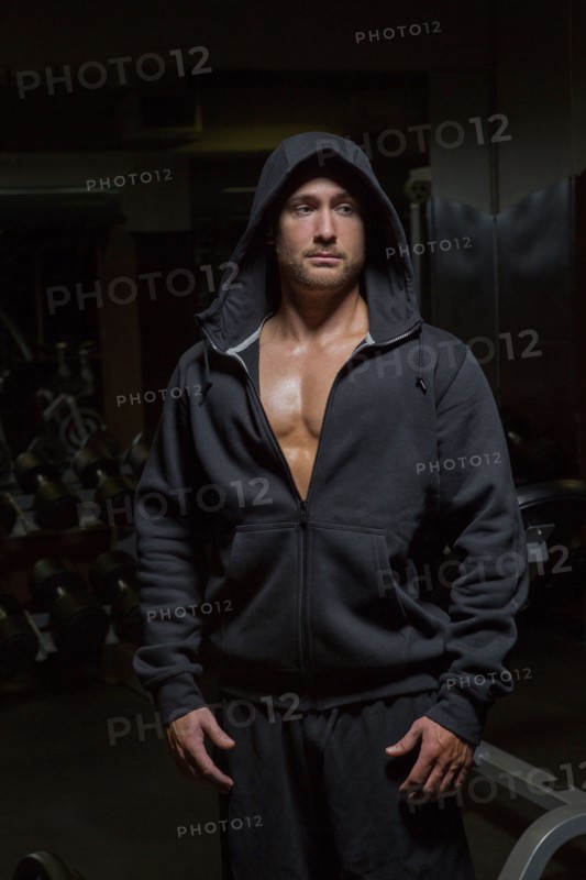 Caucasian athlete wearing hoody at night