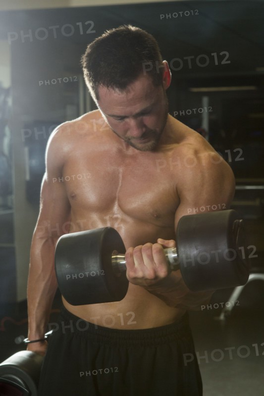 Caucasian athlete lifting weights in gymnasium