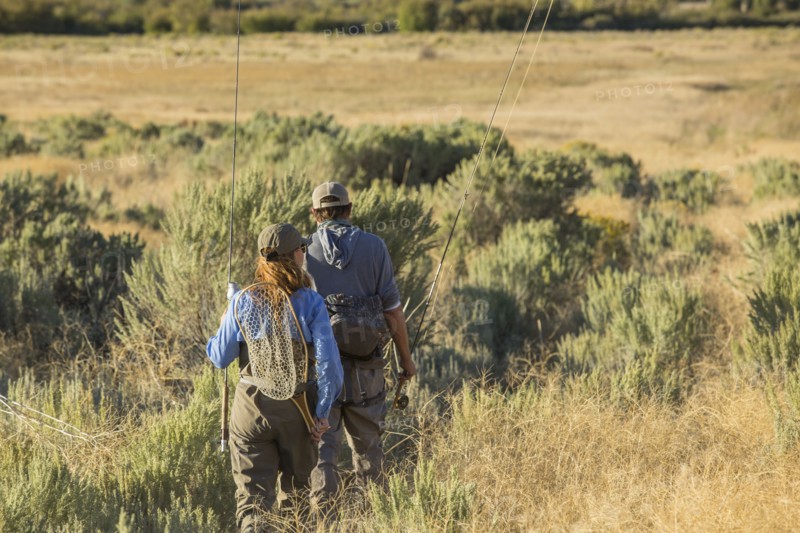Caucasian couple with fishing gear in field
