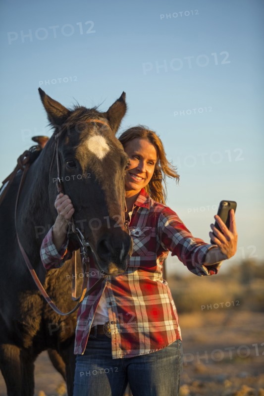 Caucasian woman taking selfie with horse