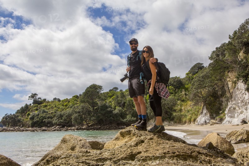Caucasian couple hiking on remote beach
