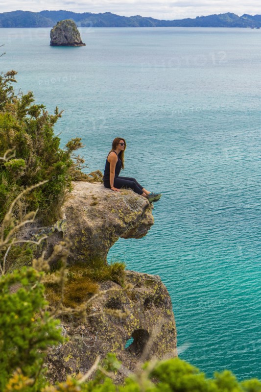 Caucasian hiker sitting on coastal cliff
