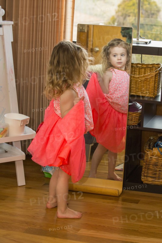 Caucasian preschooler girl playing dress-up with skirt