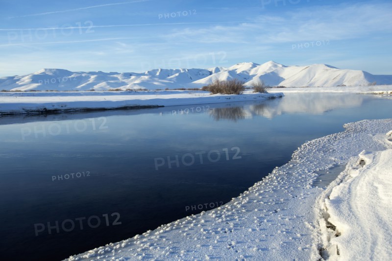 Still river in snowy remote landscape
