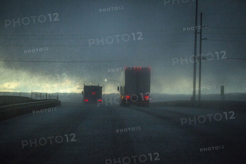 Trucks driving on stormy rural road