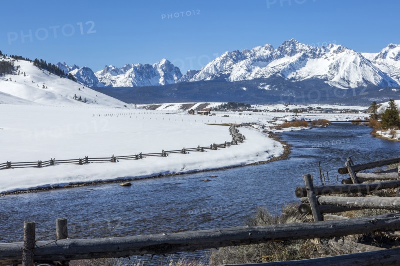 Snowy mountains and river in rural landscape