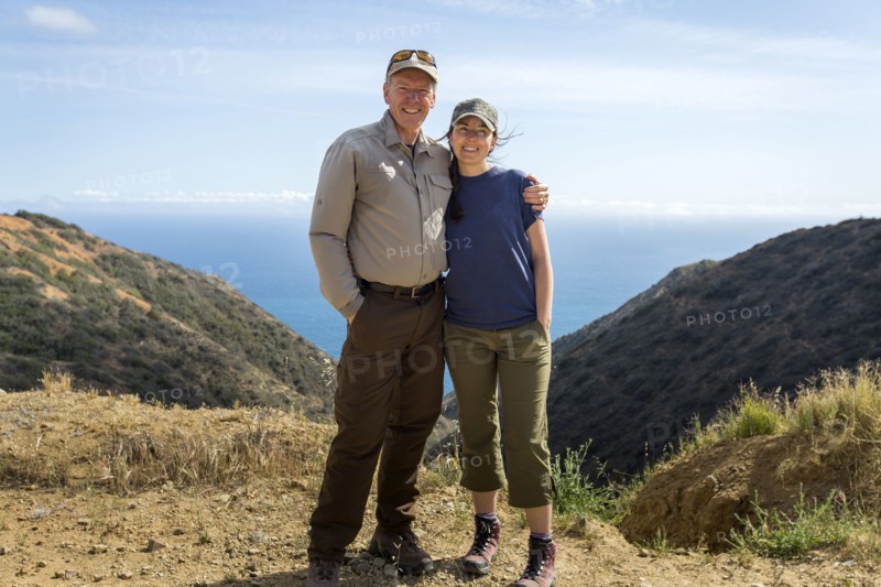 Caucasian man and daughter hugging on mountain
