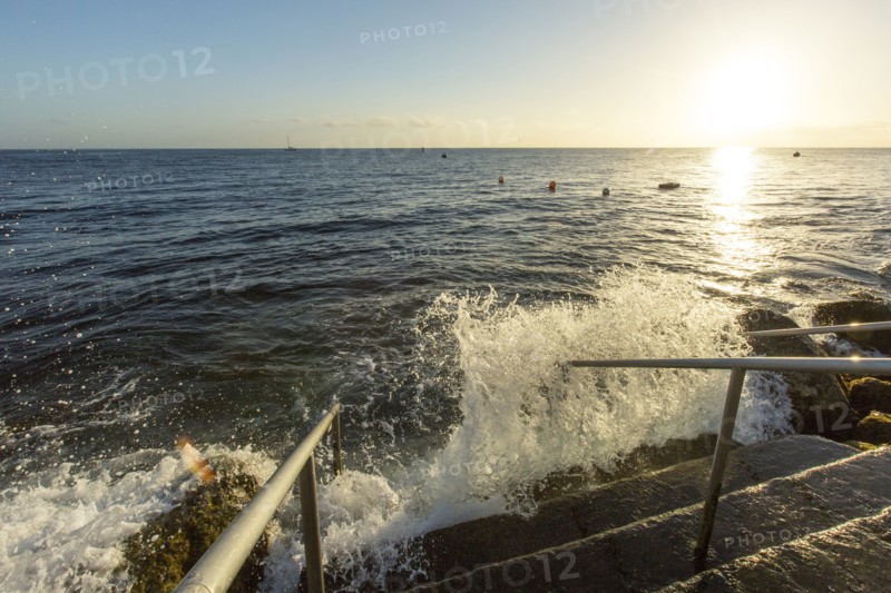 Waves splashing on staircase at ocean