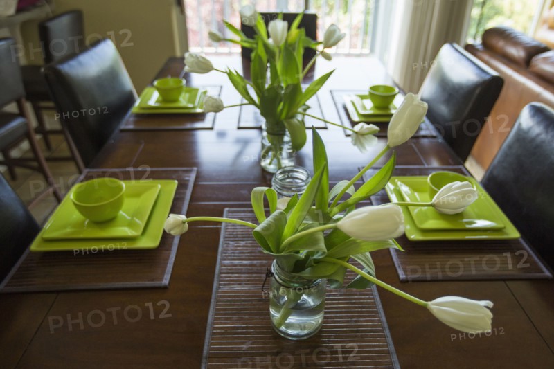 Wilting flowers in jar on dining table