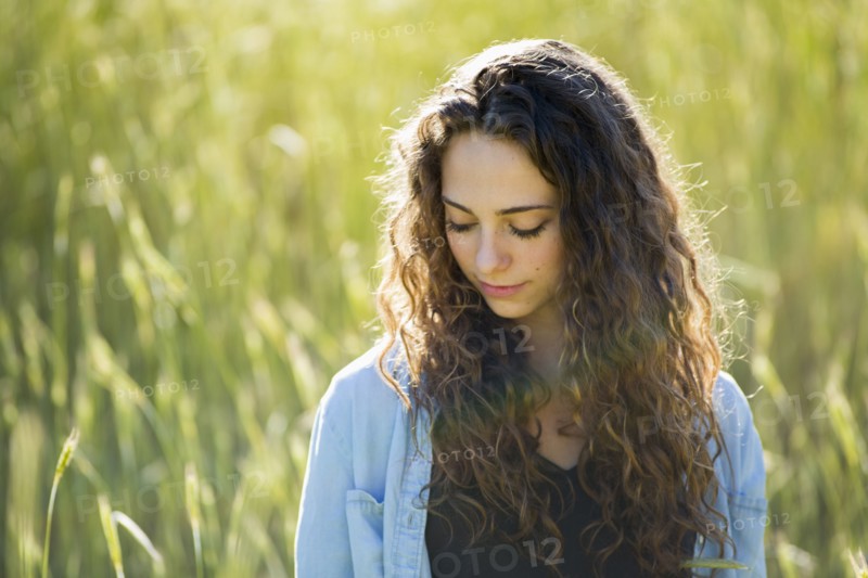 Caucasian woman standing in field of tall grass