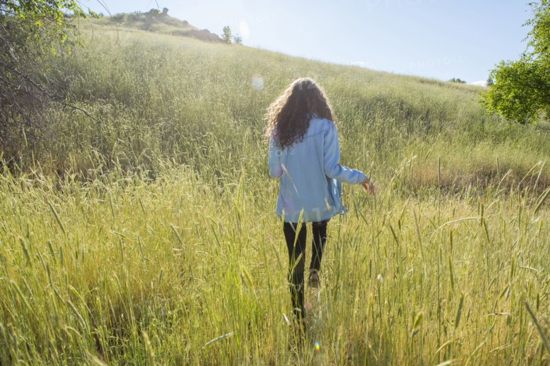 Caucasian woman walking in field of tall grass