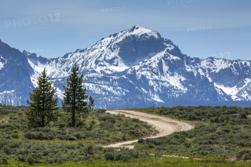 Winding dirt road near snow covered mountain range
