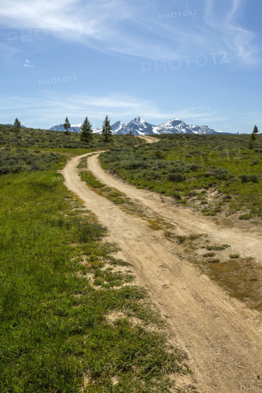Winding dirt road near snow covered mountain range