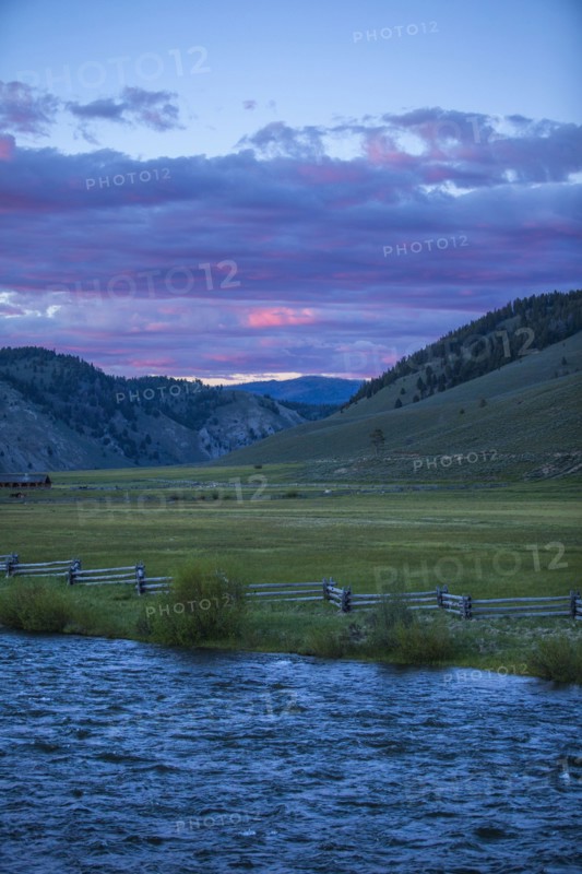 River near rolling landscape at sunset