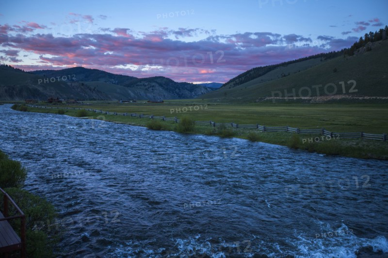 River near rolling landscape at sunset
