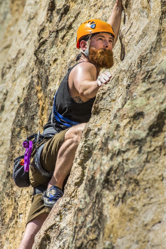 Caucasian man climbing rock