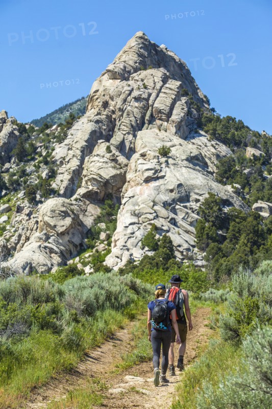 Caucasian couple hiking toward mountain