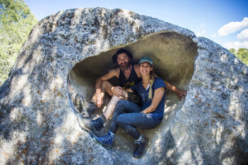 Caucasian couple sitting in rock formation