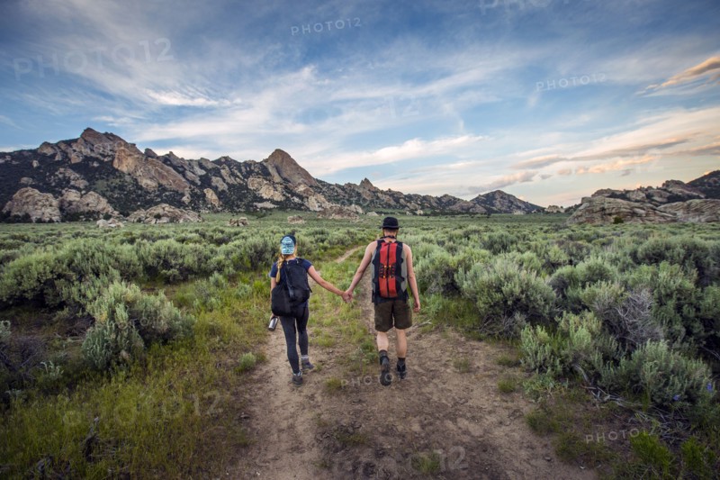 Caucasian couple hiking toward mountain